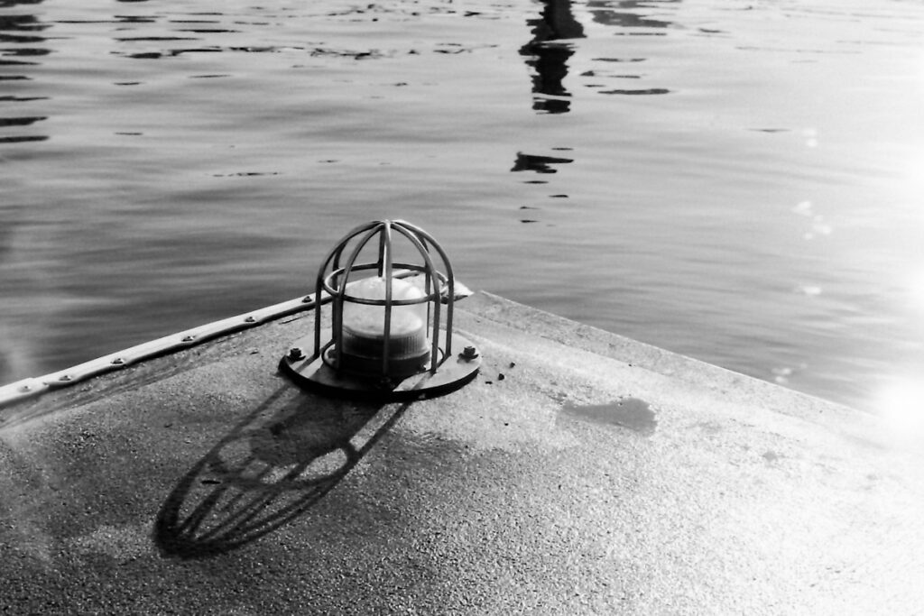 B&W photo of a caged light on the edge of a wharf